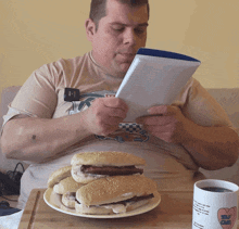 a man sits at a table with a plate of food and a mug that says self love on it