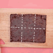 a brownie on a wooden cutting board with white lines drawn around it