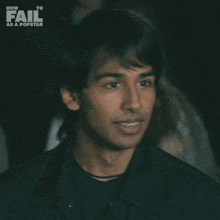 a young man says " yeah " in front of a poster for how to fail as a popstar