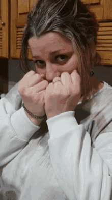 a woman with a ring on her finger is covering her mouth