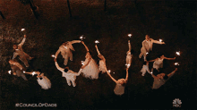 a group of people holding sparklers in a circle and spelling out the word love