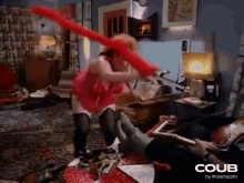 a woman in a red dress is holding a red balloon in a room .