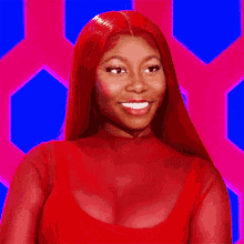 a woman with red hair is wearing a red dress and smiling .