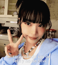 a girl giving a peace sign with the words " mi cara cuando soy de teru y no de silvi " below her