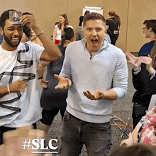 a group of people are standing in a room with the hashtag #slc on the bottom