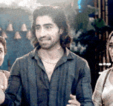 a man with long hair and a necklace around his neck smiles