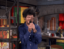 a man in a blue shirt is holding a knife in his hands