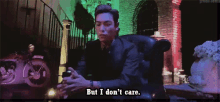 a man in a suit is sitting in a chair and saying but i don 't care .