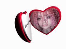 a red heart shaped mirror with a picture of a woman in it