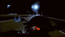 a blurry image of a person walking down a street at night .