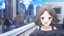 a girl with a bow on her head is standing on a balcony overlooking a city