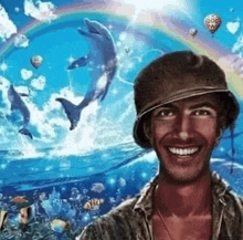 a man in a hat is smiling in front of a painting of dolphins and balloons .