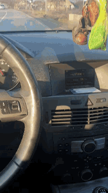 a steering wheel and dashboard of a car with the radio on