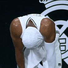 a man wearing a white tank top with the word adidas on the side