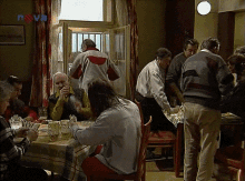 a group of people are gathered around a table in a room with a sign that says news