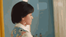 a woman with short hair is wearing earrings and a floral shirt