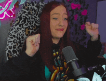a woman with red hair is sitting in front of a microphone and making a funny face