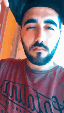 a man with a beard wears a red shirt that says arizona on it