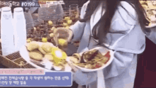 a woman is holding a plate of food in her hands .