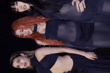 three women with red hair are standing next to each other in black dresses