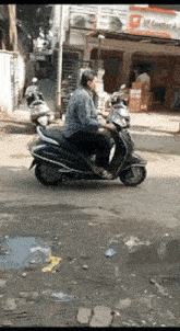 a man is riding a scooter down a city street .