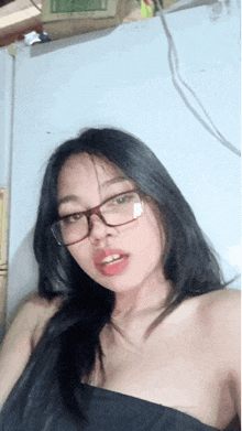 a young woman wearing glasses and a black top