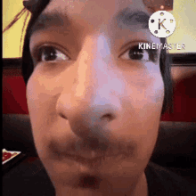 a close up of a man 's face with a k on the corner
