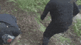 a man is holding another man 's hand while they are walking through the mud .