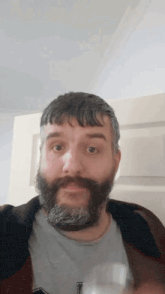 a man with a beard is holding a glass of wine