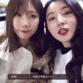 two girls are standing next to each other and one of them has a foreign language written on her face