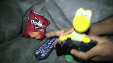 a bag of doritos chips next to a remote