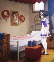 a girl stands in front of a bed in a bedroom