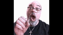 a man wearing glasses and a cross necklace is making a funny face