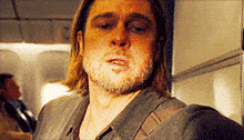 a man with a beard is wearing a plaid shirt