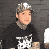 a man wearing a hat with the letter s on it and a shirt that says rebelfire