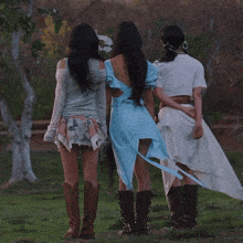 three women standing next to each other with their arms around each other