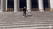 a man is standing on top of a set of stairs .