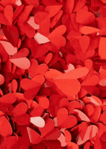 a pile of red and white paper hearts on a white background .