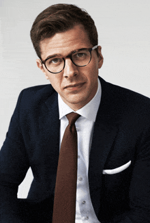 a man in a suit and tie with glasses on
