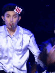 a man wearing a beret and a white shirt is singing into a microphone .