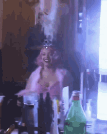 a woman with pink hair is sitting in front of a mirror