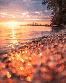 a sunset over a body of water with the city in the background