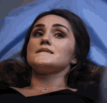 a close up of a woman laying on a blue sheet