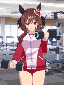 a girl in a red jacket is holding a pair of dumbbells