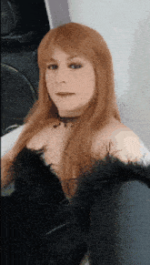 a woman with red hair is wearing a black top