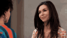 two women are looking at each other and smiling