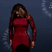 a woman in a red dress is standing on a stage