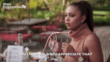 a woman sits at a table with a sign that says real housewives out of context
