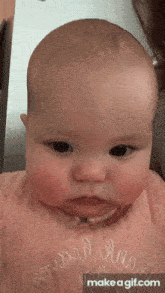a baby is wearing a pink shirt that says " make a gif "