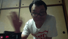 a man wearing glasses and a korg t-shirt